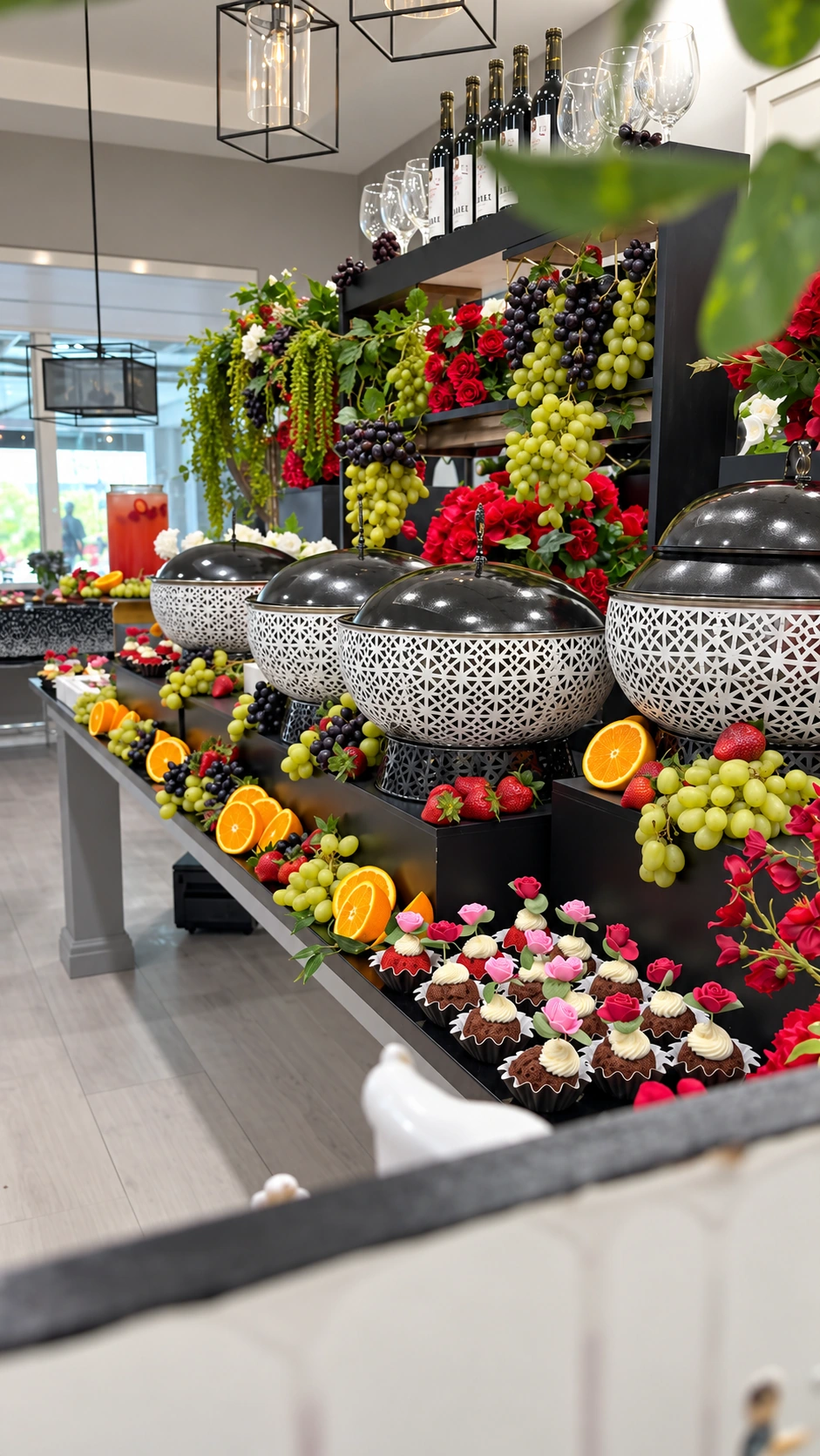 An elaborate buffet display with chafing dishes, fresh fruit and desserts