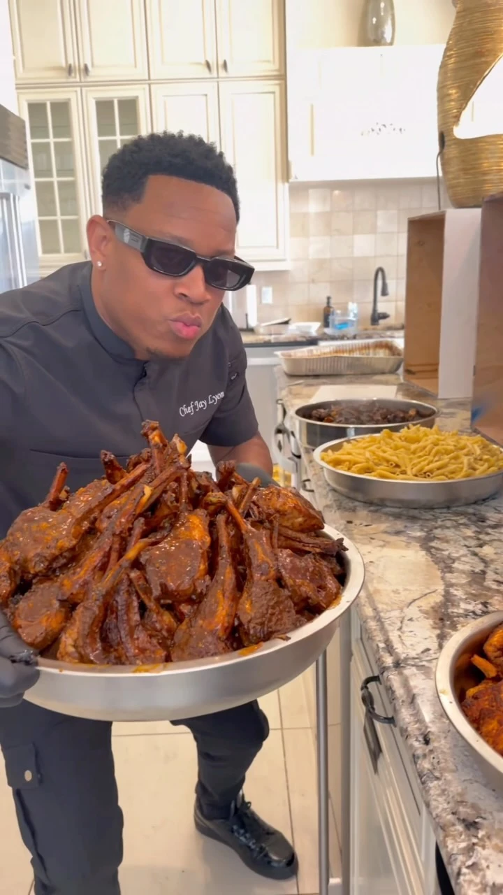 Chef Jay presenting a platter of lamb chops in a kitchen